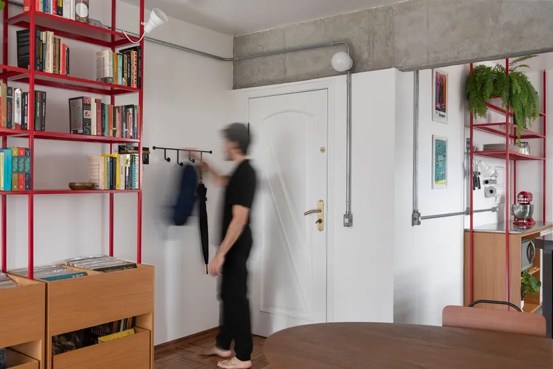 Entryway with white arched door, exposed concrete beam and blurred figure in motion