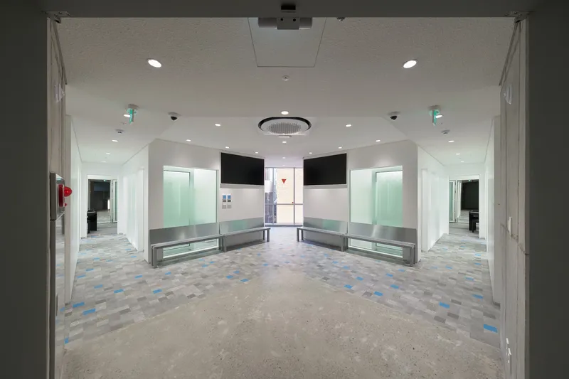 Interior lobby with patterned terrazzo floor, built-in benches and glazed openings at both ends
