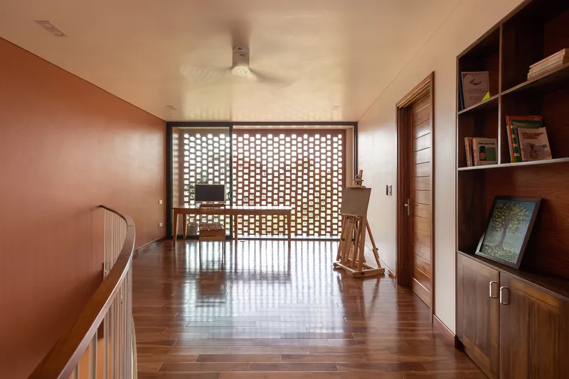 Upper hallway with timber flooring leading to a perforated brick screen and rocking chair