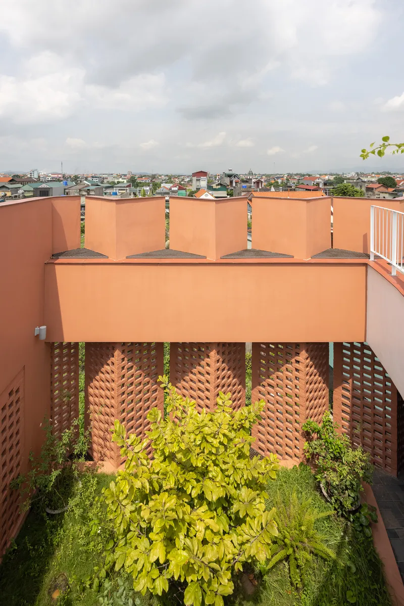 Rooftop terrace with perforated brick screens and planted bed overlooking the surrounding neighborhood