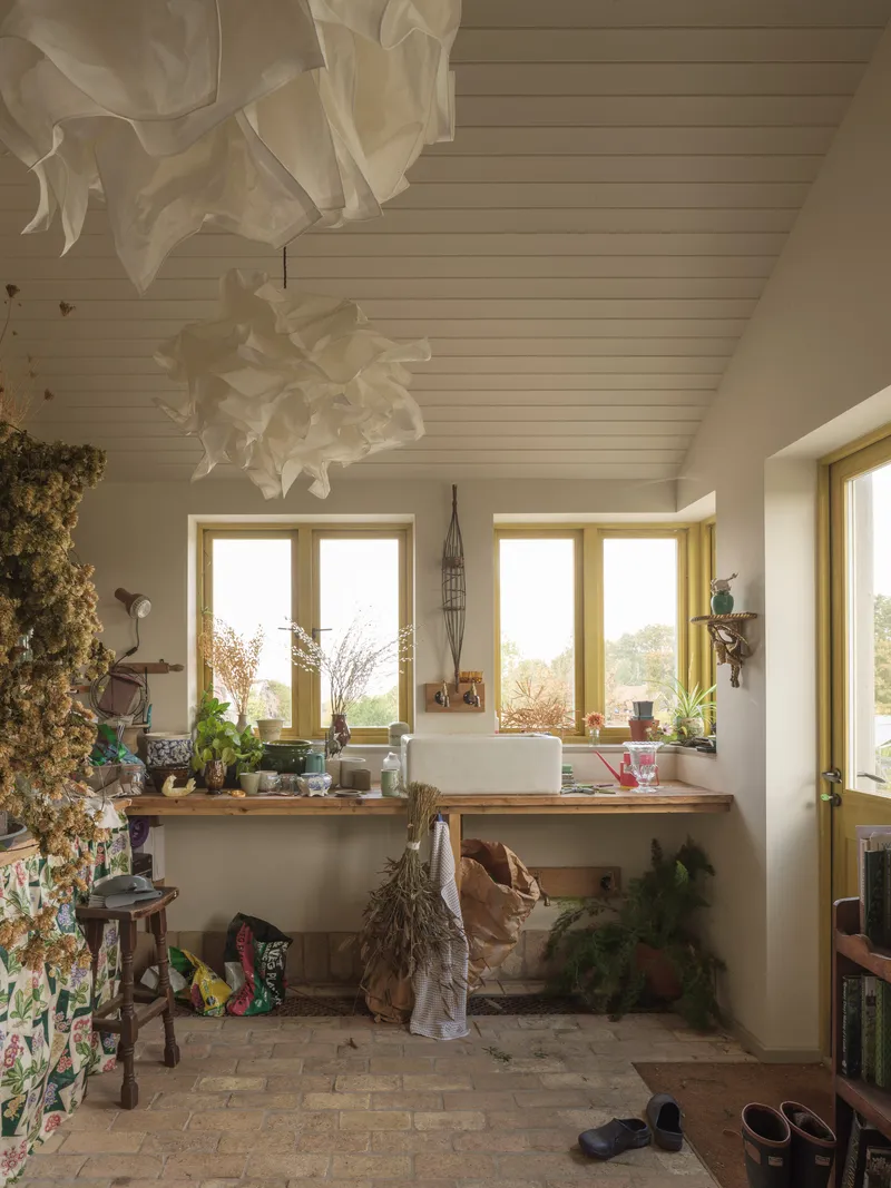 Bathroom with white tongue-and-groove ceiling, timber-framed windows and sculptural pendant light