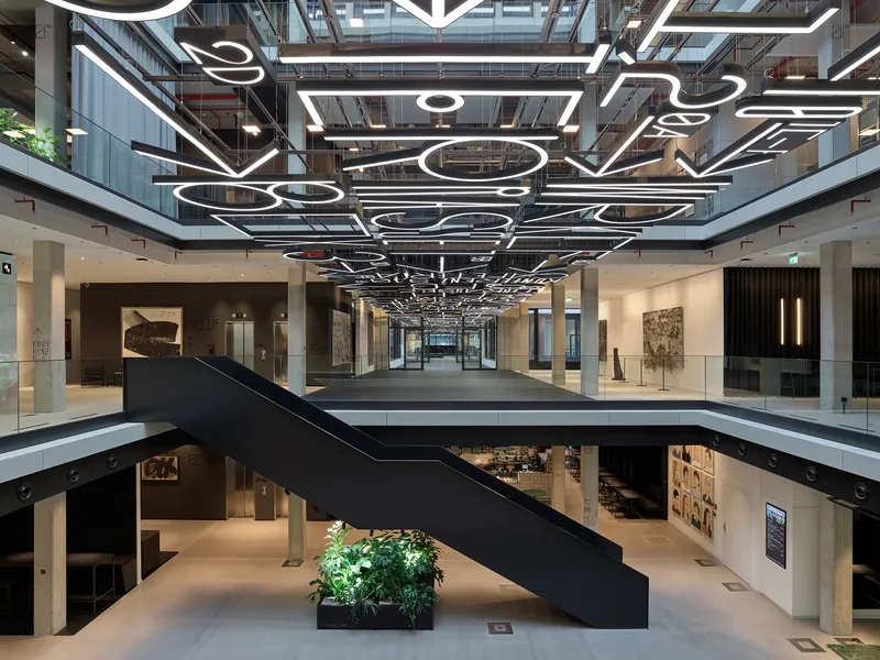 Atrium view showing the black steel bridge, custom linear pendant lights and gallery spaces on lower floors