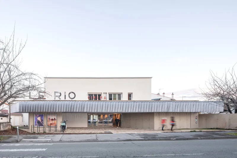Street view of the cinema facade with corrugated metal canopy and bare winter trees