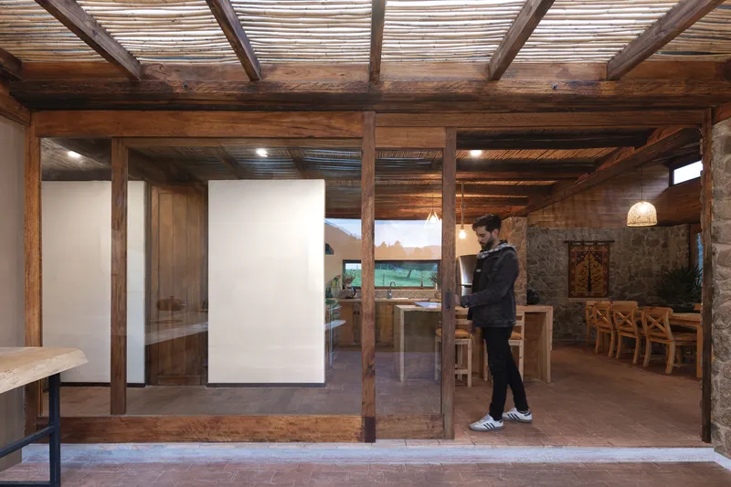 Timber frame threshold with sliding glass panels and a figure standing in the passage
