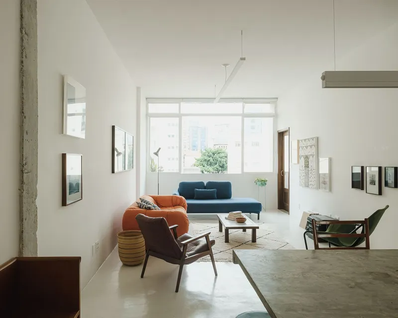 Living room with mid-century seating facing a large gridded window with diffused daylight