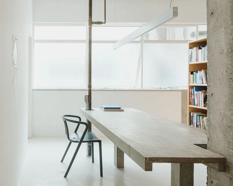 Work table at frosted glass window with steel pipe penetrating the concrete surface