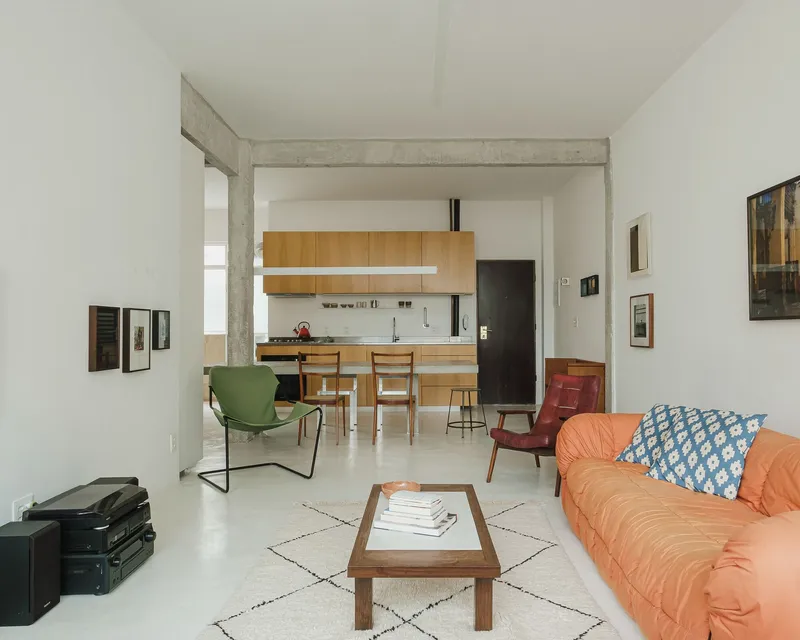 Open living and kitchen area with exposed concrete beams and polished concrete floor