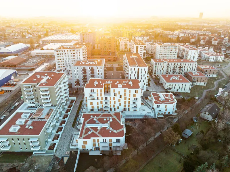 Aerial view of the white residential blocks with terracotta roofs in golden sunset haze