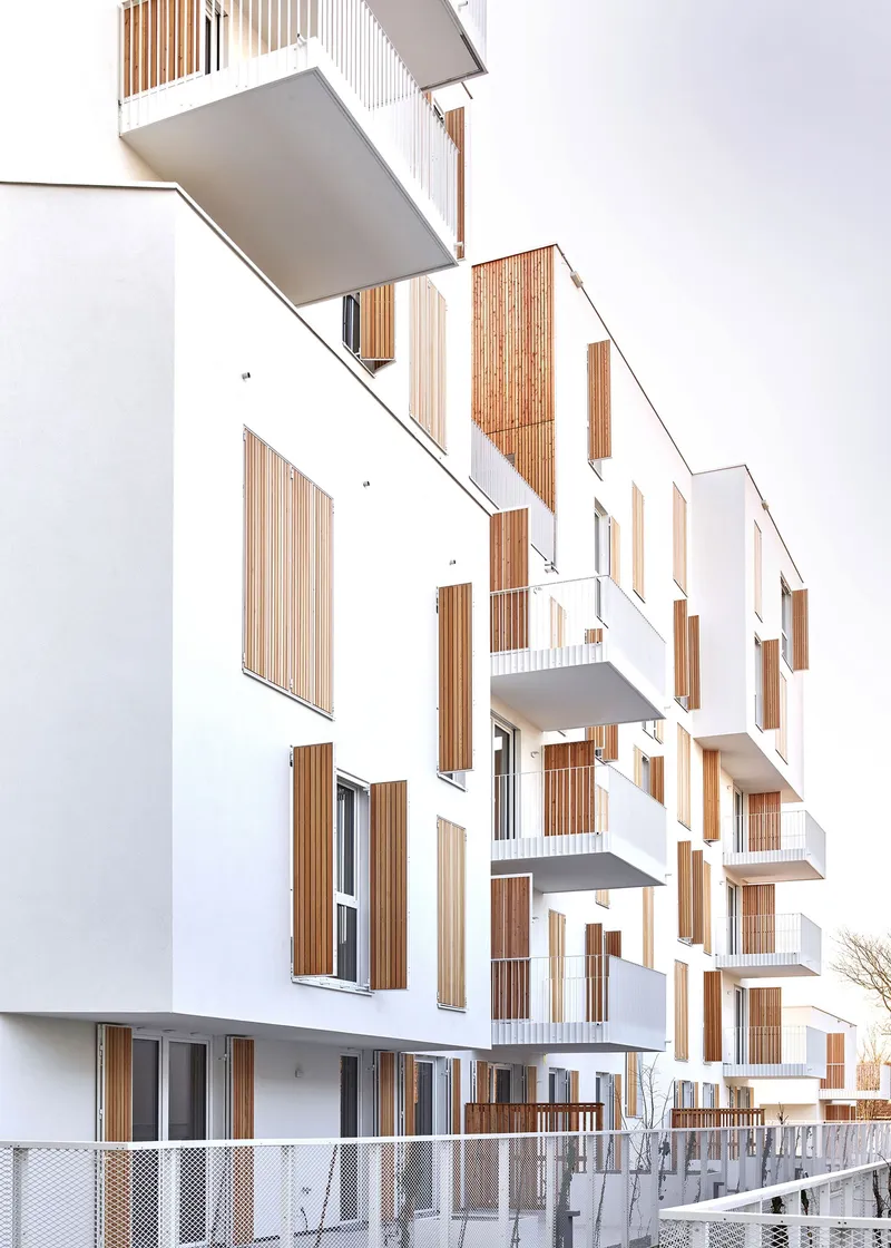 Oblique view of the staggered white balconies with vertical timber screening panels