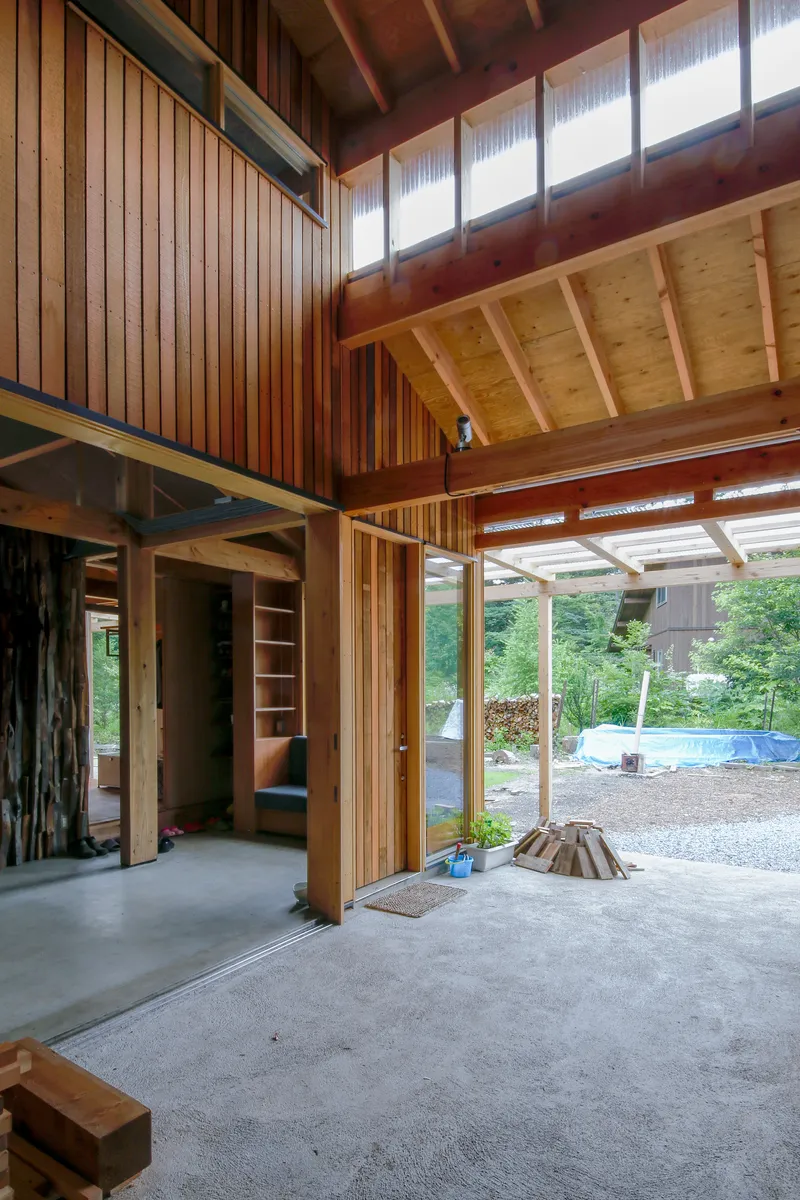 Entry threshold with concrete floor opening to a garden courtyard with gravel and trees beyond