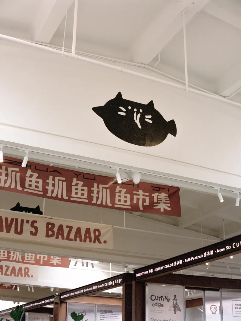 Black cat silhouette sign mounted on white wall above retail graphics and track lighting