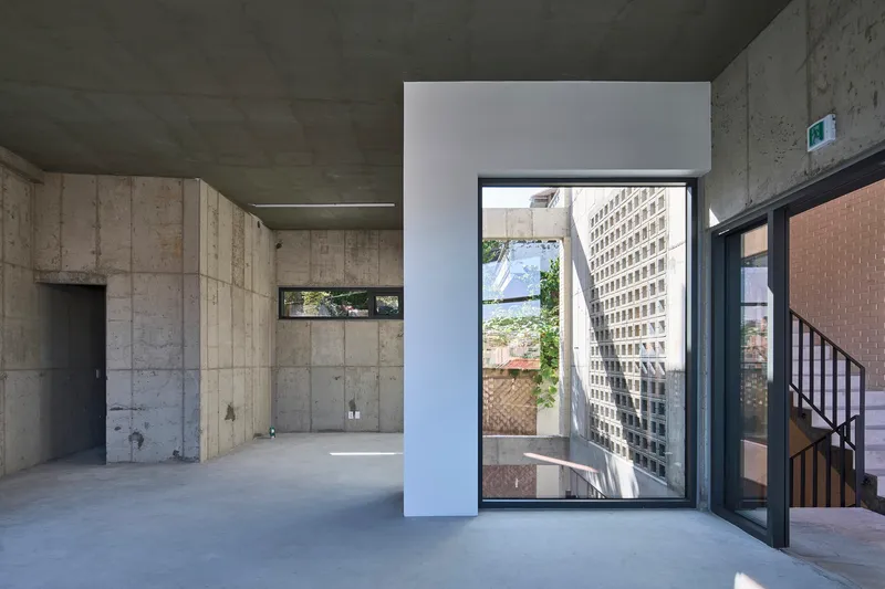 Tall window framing a view of the perforated brick screen and adjacent garden terrace