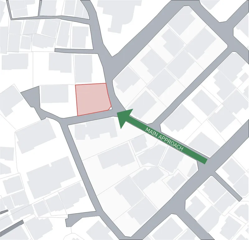 Site plan diagram showing the building footprint in pink and main approach arrow in green