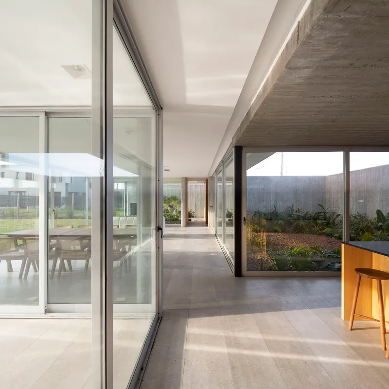 Glass corridor linking interior spaces with views to planted courtyards on both sides