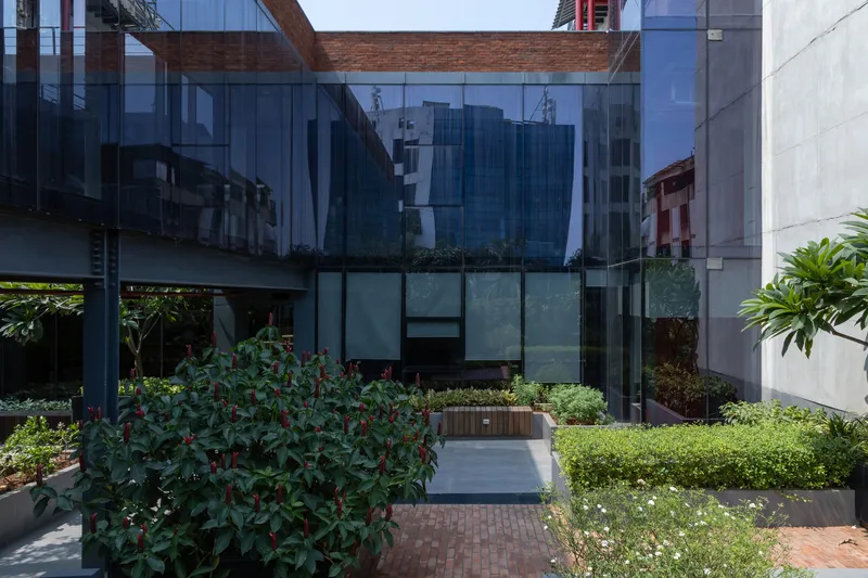 Glass facade overlooking the garden courtyard with brick paving and planted beds below