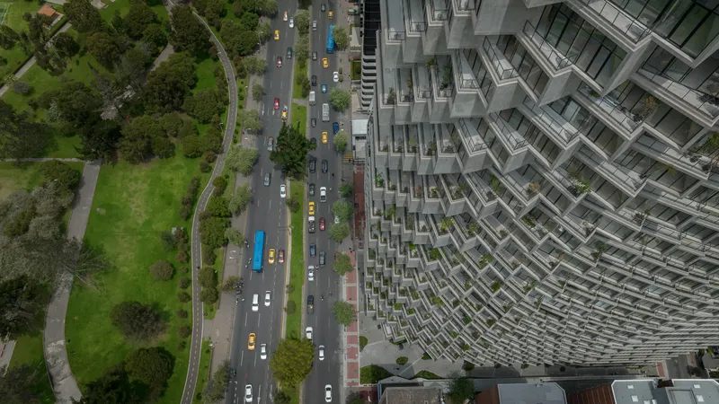 Aerial view of the terraced facade beside a tree-lined avenue with passing traffic