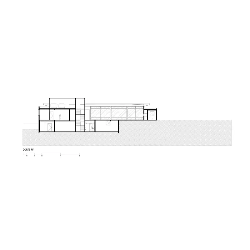 Section drawing showing split-level interior volumes with clerestory windows and adjacent sloped site