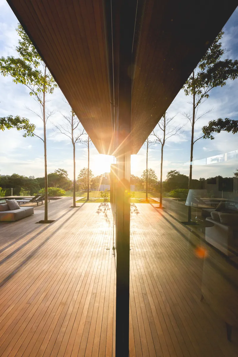 Underside view of the timber-clad overhang with sunburst filtering through the column at sunset