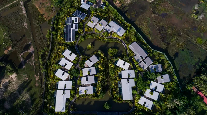 Top-down view of the curving cluster of white-roofed villas arranged around landscaped courtyards and pathways
