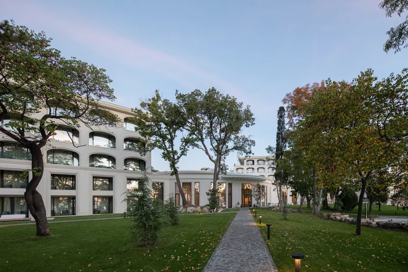 Stone path through the courtyard garden leading toward the illuminated portico at dusk