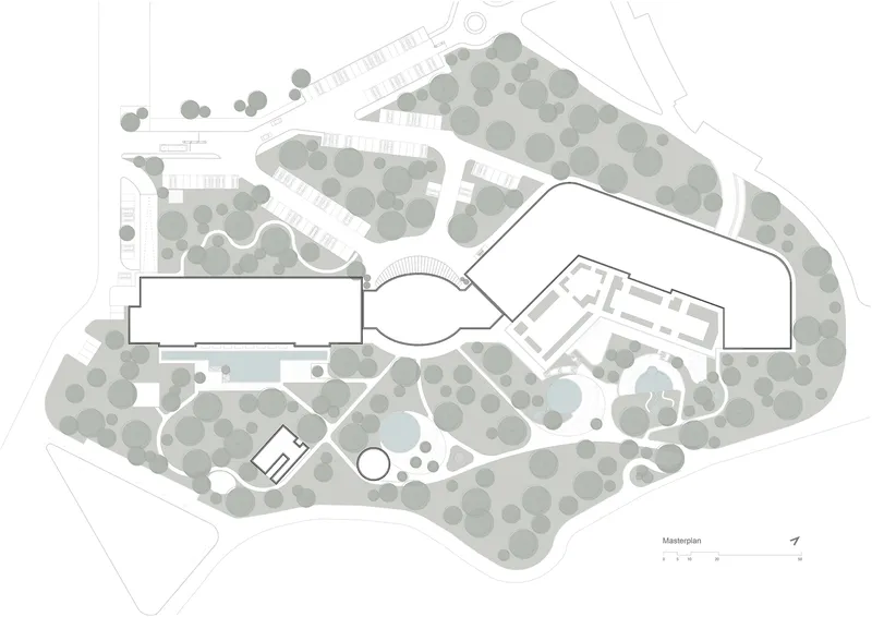 Site plan drawing showing building footprints surrounded by tree canopies and landscaped pathways