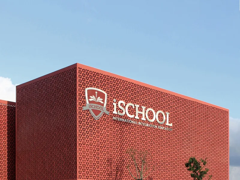 Close-up of the perforated terracotta screen facade corner against a clear blue sky