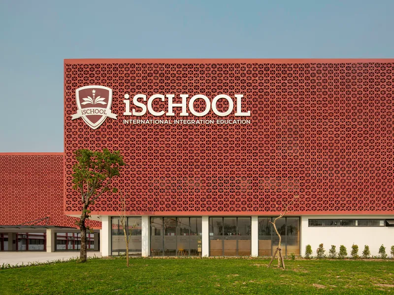 Perforated terracotta screen wall above glazed ground floor with young trees planted in front