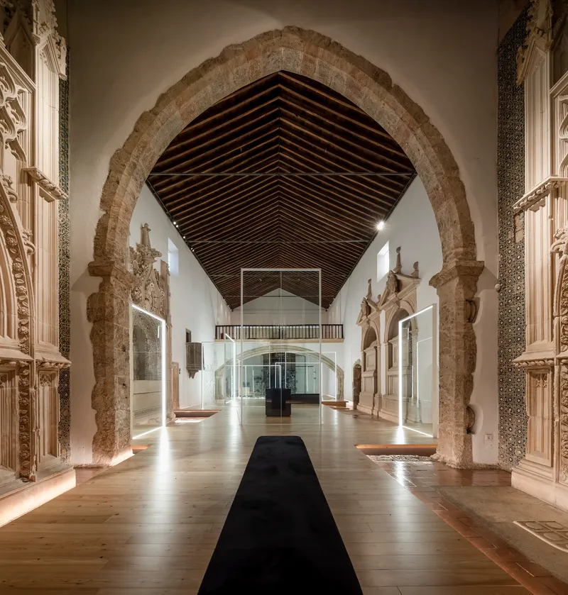 Central black carpet runner beneath pointed arch with timber battens overhead
