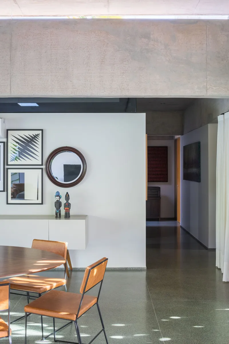 Dining area with polished concrete floor and glimpse through corridor to adjoining rooms beyond