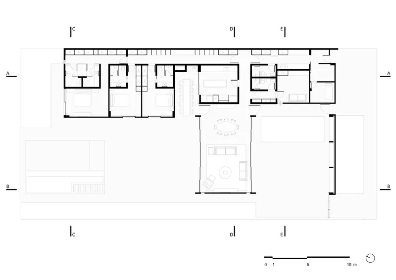 Floor plan drawing showing L-shaped layout with service wing, central living area and pool terrace
