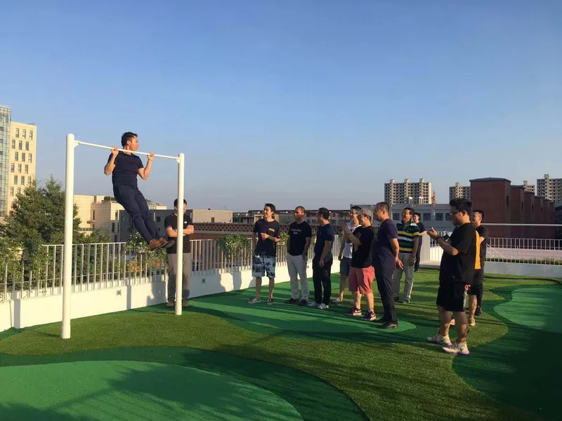 Rooftop exercise area with white pull-up bar and users gathered at dusk