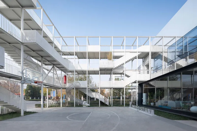 White steel frame structure with exposed floors and staircases surrounding a central courtyard