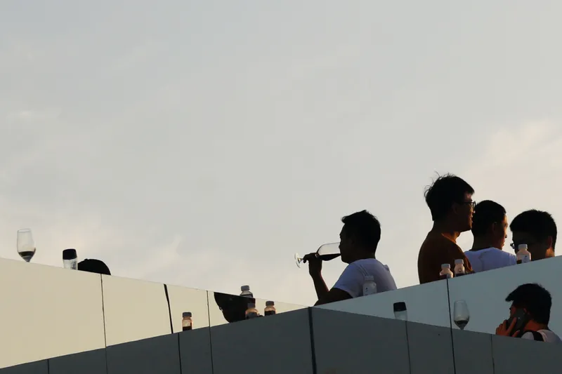 Frosted glass rooftop balustrade with figures silhouetted against the sunset sky