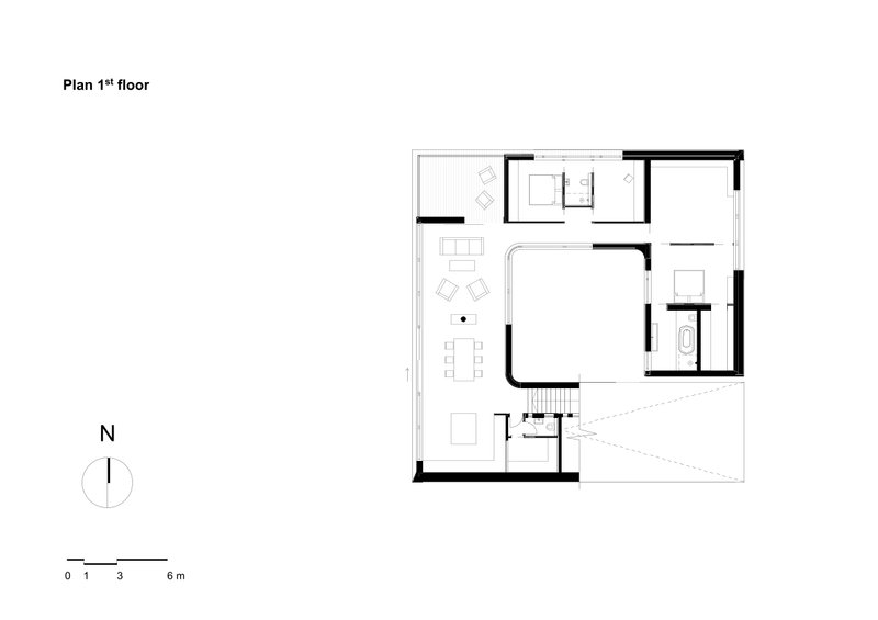 First floor plan drawing showing an open living area with dining table and a central staircase