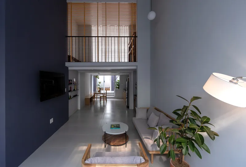 Living room looking through double-height space toward dining area with mezzanine above
