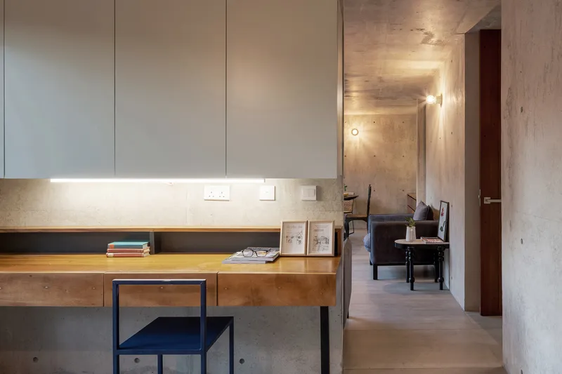 Timber workstation with integrated shelving under pale cabinetry and strip lighting