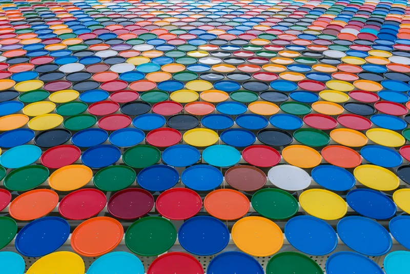 Roof view of multicolored circular glass panels arranged in overlapping rows creating patterned canopy