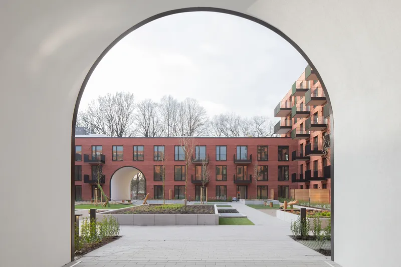 View through one archway to another framing the landscaped courtyard with bare winter trees beyond