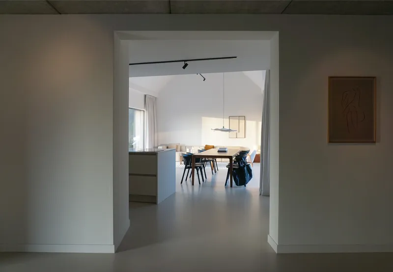 Doorway framing a view through kitchen to dining table with pendant light