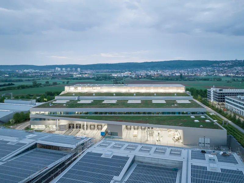 Aerial view of the industrial complex with photovoltaic arrays on rooftops at dusk