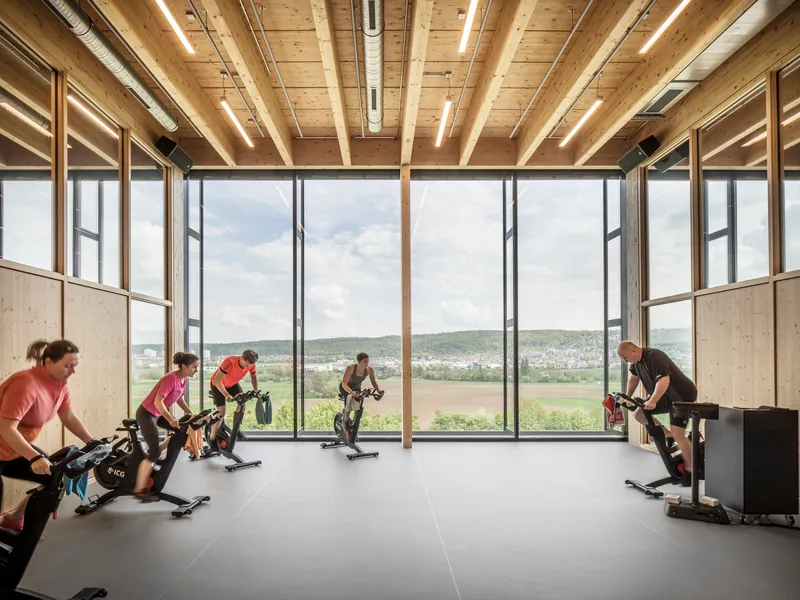 Training room with timber ceiling beams and floor-to-ceiling windows overlooking fields
