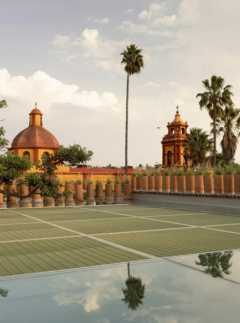 Rooftop tennis court with historic domed towers and palm trees visible beyond the balustrade