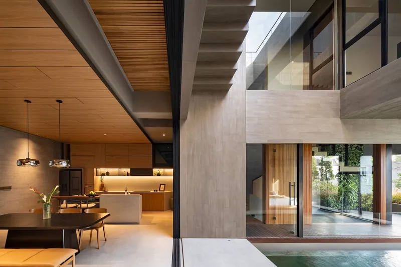 Open-plan kitchen and dining area with timber ceiling, pendant lights overlooking the courtyard pool