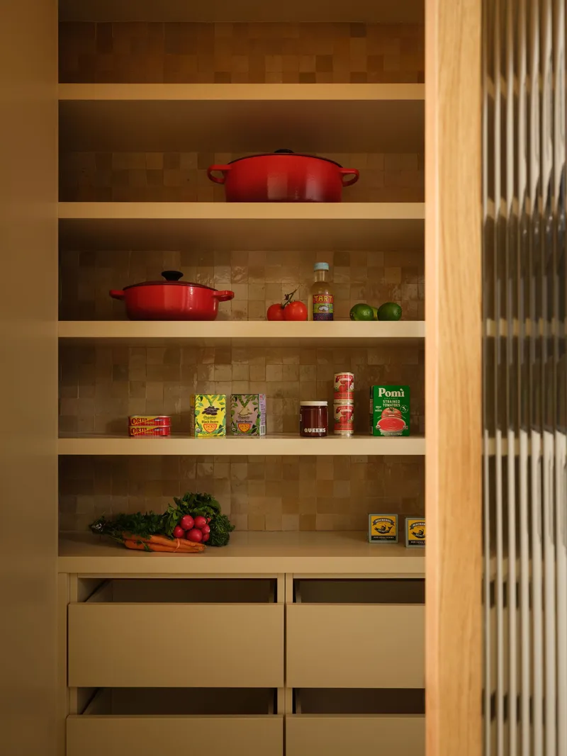 Open shelving with mosaic tile backing, reeded glass sliding door and produce displayed on timber shelves
