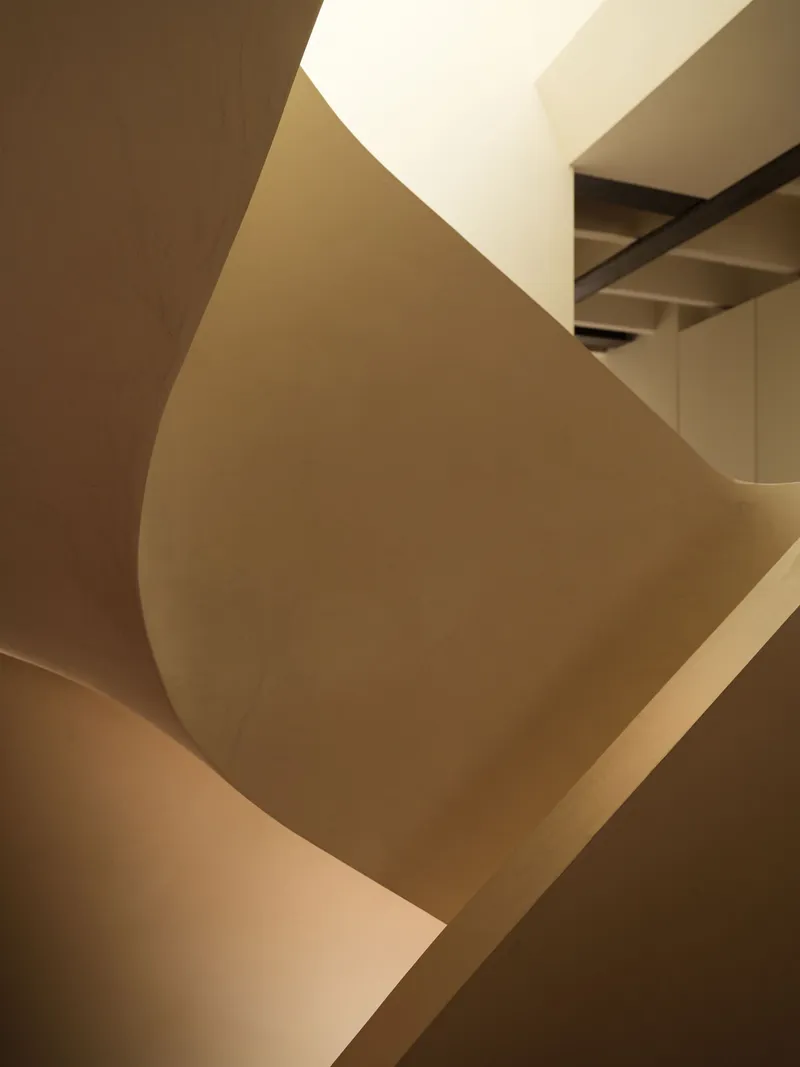 Abstract view of sculptural staircase volumes intersecting under ambient daylight