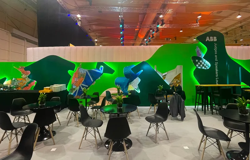 Interior of the lounge space with seating clusters and photographic murals mounted on the green partition walls