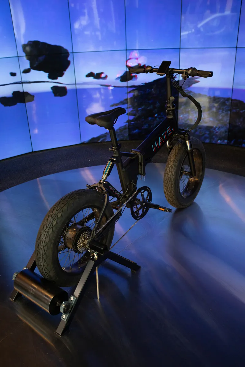 Single bike mounted on a trainer before a curved blue video screen display