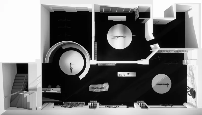 Top-down view of an architectural model showing three circular volumes within a rectangular black floor plan