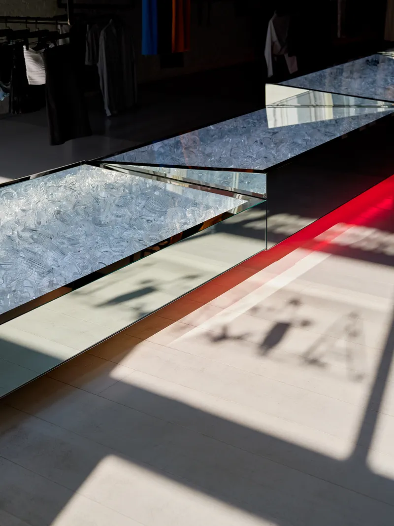 Display platform with translucent marbled surface casting red and amber shadows on polished floor