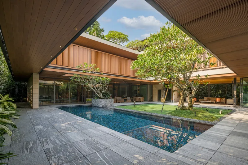 Covered walkway framing the interior courtyard pool and lawn under a slatted timber soffit